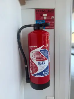 Red fire extinguisher mounted on wall